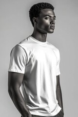 Obraz premium A man stands with his arms relaxed, wearing a white T-shirt and possibly awaiting further instruction
