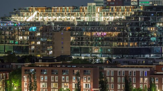Aerial timelapse of Katendrecht peninsula at night and Maashaven harbour in Rotterdam, Netherlands. Illuminated city skyline, modern buildings glowing windows and traditional Dutch waterfront houses