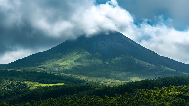 The green landscape with snow-capped mountains and fluffy clouds stretches towards the blue sky