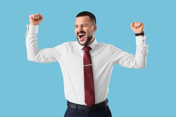 Emotional young businessman with tie on blue background