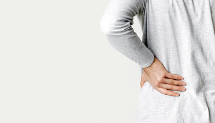 Muscle spasm, rheumatism concept. Man holds to his back with hand, back