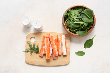 Wooden board with tasty crab sticks, dill and bowl of spinach leaves on white background © Pixel-Shot