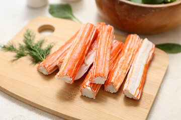 Wooden board with tasty crab sticks and dill on white background, closeup © Pixel-Shot