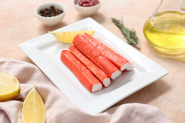 Plate with tasty crab sticks and different spices on beige background © Pixel-Shot