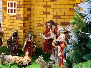 Christmas nativity scene with family. Christmas Manger scene with figurines including Jesus, Mary, Joseph, sheep and magi.