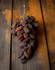 A bunch of dark raisins on a rustic wooden background.