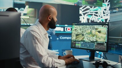 Middle eastern employee monitoring delivery truck gps coordinates to ensure fast shipment in...