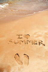I Love Summer Written on Sandy Beach
next to footprints,