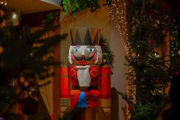 Red Nutcrackers doll.Symbol of Christmas and New Year.Beautiful winter festive background in red tones.Christmas holiday symbol on a blurred background.Christmas toys and decorations. 
