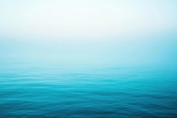 Obraz premium A serene view of calm ocean waters blending with a soft blue sky.