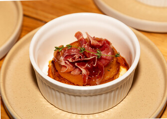 Delicious pancake with prosciutto and thyme on a plate