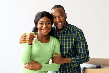 Happy Owners. Cheerful Black Spouses Posing With Keys From Their New Home And Smiling At Camera,...