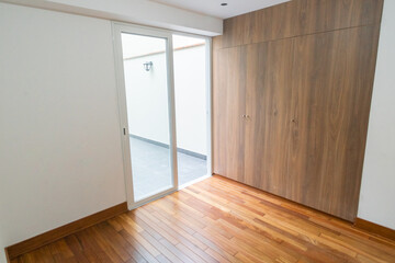 Sala de departamento con piso de melamina, con mampara y vista a patio iluminado