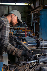 Skilled worker engaged in workshop activities focused on machinery maintenance and repair