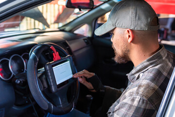 An Automotive Technician is Using a Diagnostic Tool in the Car Today for Optimal Performance