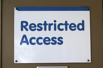 Restricted Access sign attached to a brown door