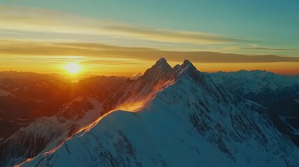 Aerial view of majestic snowy mountain peaks at sunrise with vibrant colors illuminating the ski resort landscape in the Caucasus region