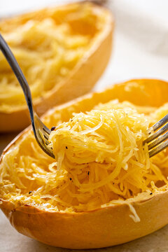 Spaghetti squash baked and pulled apart ready to eat on a baking pan