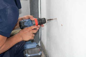 person hands hold hammer drill close up