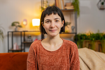 Portrait of smiling young Caucasian woman with short brown hair looking at camera. Happy content...