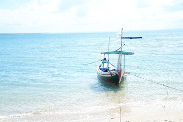 Quiet Beach with Traditional Boat and Clear Blue Waters