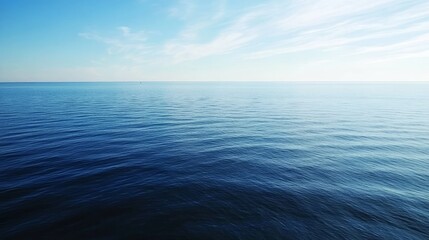 Obraz premium Aerial view of the Baltic Sea, with calm blue waters and small islands scattered across the horizon, captured from a drone. The sky is clear with a few clouds, emphasizing the vastness of the sea