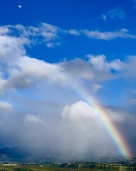 Kauai canyon, rainbow with three quarters daylight moon