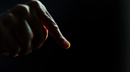 Obraz premium hand making key gesture with its index finger, illuminated against dark background, conveys sense of focus and intention