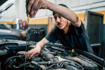 Young Latino Man Changing Oil in a Car Engine