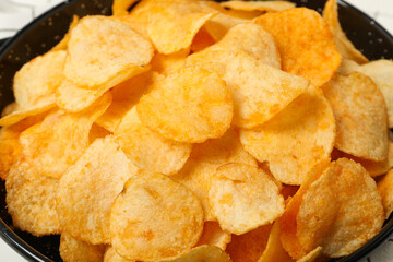 Pile of crispy potato chips close up view