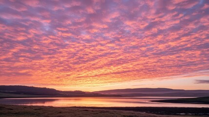 A vibrant sunset over a tranquil water body, reflecting colorful clouds in the sky.