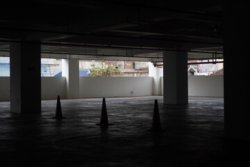 A dark and quiet basement parking lot with orange road dividers © Zalfa R