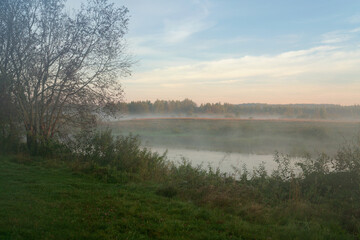 The valley of the Sorot River near the Mikhailovskoye Estate of the Pushkin Museum-Reserve at dawn on a foggy summer morning, Pushkinskiye Gory, Pskov Oblast, Russia