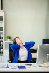 Asian businesswoman office worker suffering from neck pain after had a long day at her office desk.