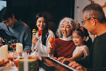 Multi-Generation Family Celebrate Christmas At Home Wearing Santa Hats And Antlers Opening Presents