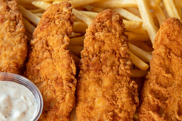 fried chicken nuggets or strips and fries, close up