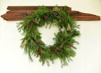 Natural Evergreen Wreath with red berries on White Wood Background