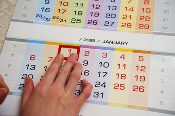 The finger moves the red frame to one on the calendar sheet. Appointment scheduling. anticipation...