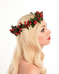 close up portrait of beautiful blonde female model wearing holly and ivy Christmas  fantasy wreath crown headdress. isolated silhouette, looking away in side profile on white studio background.