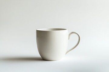 Obraz premium A single, empty, off-white ceramic mug on a white background.