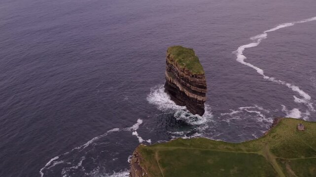 Aerial high angled overview of Downpatrick Head coastline with waves crashing around the Dun Briste sea stack