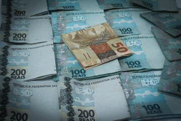 This photographic illustration shows notes of one hundred and two hundred reais and a note of 10 reais. The Real is the current currency in Brazil.