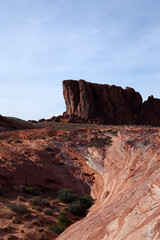 Obraz premium A bright red rock standing alone in Red Rocks Canyon. Futuristic landscape with red and white stripes going to the rock.