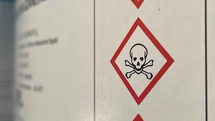 Chemical Safety Signs Displayed on 200-Liter Drums Stored in Industrial Warehouse