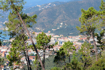 View of sea and city of Liguria from mountain. Nature and traditional buildings. Sunny day. Cove and landscape of Mediterranean Sea. Tourism and vacation. 