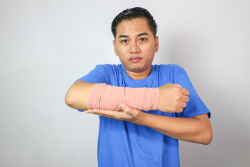 Broken hand injury, Asian man with hand operation with pressure bandage in hospital building, Hand with wrapped plaster and arm sling.