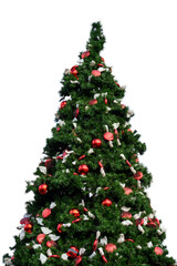 Large artificial Christmas tree decorated with classic red bulb ornaments and red and white candy shaped ornaments outdoors, celebrating the Christmas holiday season
