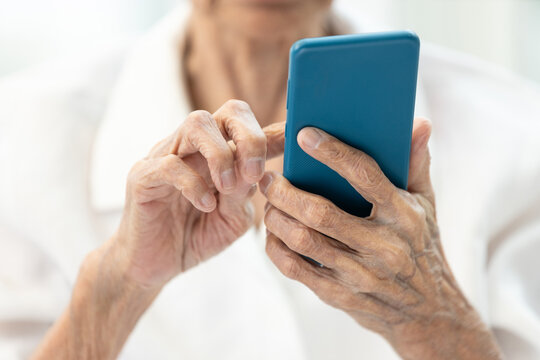 Closeup of hands,Asian senior woman using smartphone,old elderly holding mobile phone,concept of technology, financial deception,cybercrime,victim of scams,internet fraud,online scams, cyber threats