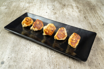 Fried chinese dim sum dumpling in the plate on the table