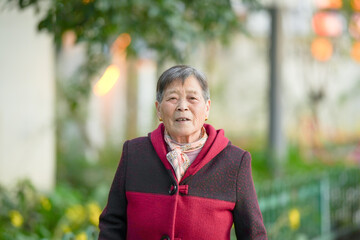 A Chinese woman in her 70s walks along a river in Qingpu District, Shanghai, China during the cold winter season.